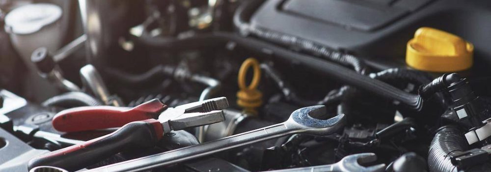 Mechanic hand checking and fixing a broken car